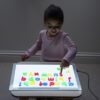 kind met letters op lichtbak